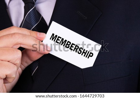 Businessman putting a card with text membership in the pocket