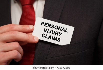 Businessman Putting A Card With Text Personal Injury Claims In The Pocket