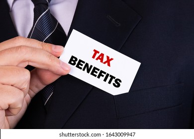 Businessman Putting A Card With Text Tax Benefits In The Pocket