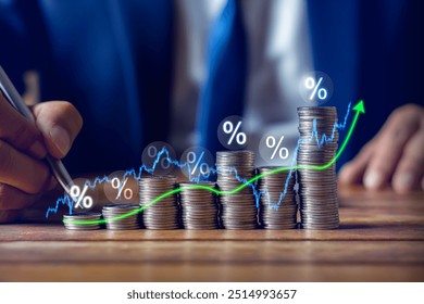 Businessman putting down money, pointing with pen and showing candlestick symbol for investing, finance, saving money, interest rate or dividend investment, business growth concept. - Powered by Shutterstock