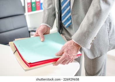 Businessman Putting Files On His Desk At Office