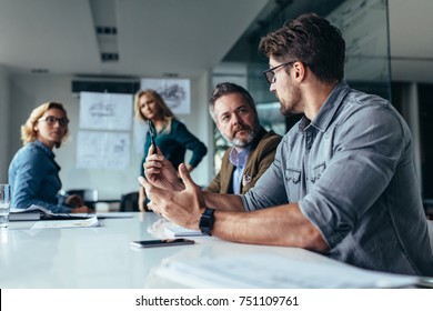 Businessman putting forward his suggestions to colleagues. Startup business team on meeting in modern bright office. - Shutterstock ID 751109761