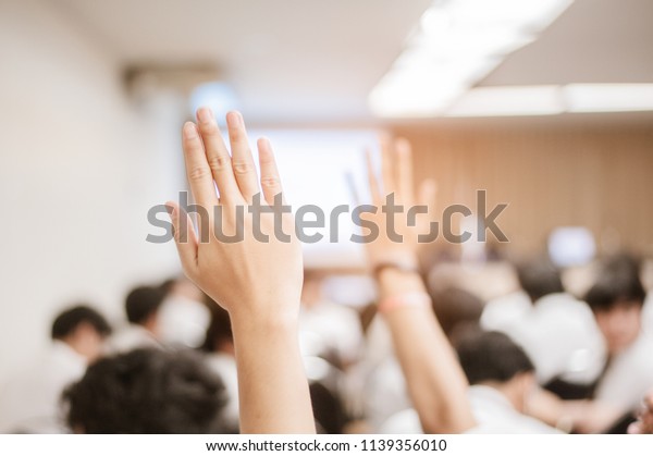 businessman\
raising hand during seminar. Businessman Raising Hand Up at a\
Conference to answer a\
question.