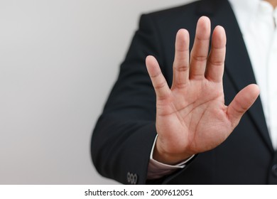 businessman raising his hand in front indicating order to stop, forbid, invalid. Corruption, illegal, anti-corruption concept.