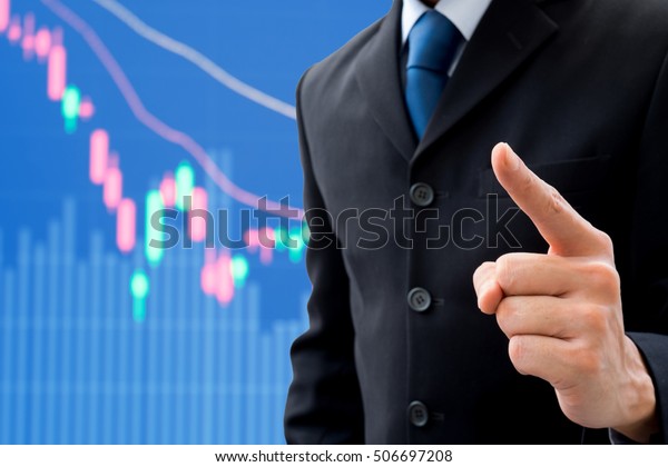Businessman
raising his pointing finger showing that he is getting an idea and
strategy to success in business in bad economy. Business and stock
market decreasing down in background
graphic.