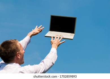 Businessman reaching out to type on laptop computer floating away in blue sky - Powered by Shutterstock