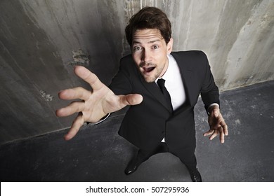 Businessman Reaching Up Towards Camera