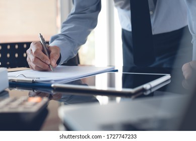 Businessman Reading Document Before Signing Business Contract Or Partnership Agreement With Digital Tablet On Desk. Corporate Man, Accountant Working In Modern Office.