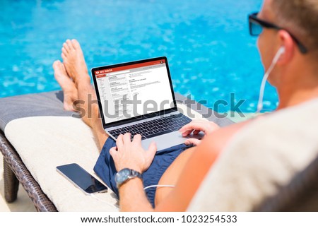 Businessman reading email by the pool
