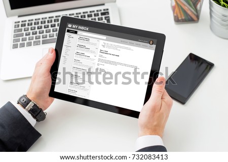 Businessman reading email on tablet computer. All content is made up.