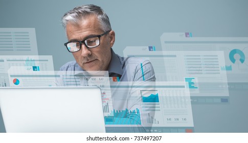 Businessman Reading Financial Reports On Visual Screens And Working With A Laptop, Finance And Technology Concept