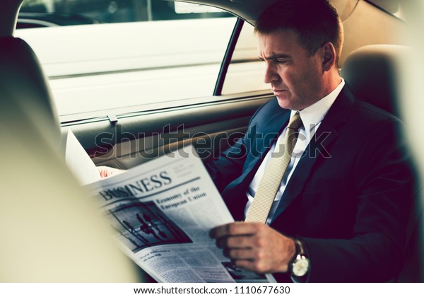 Businessman reading the news\
in the car