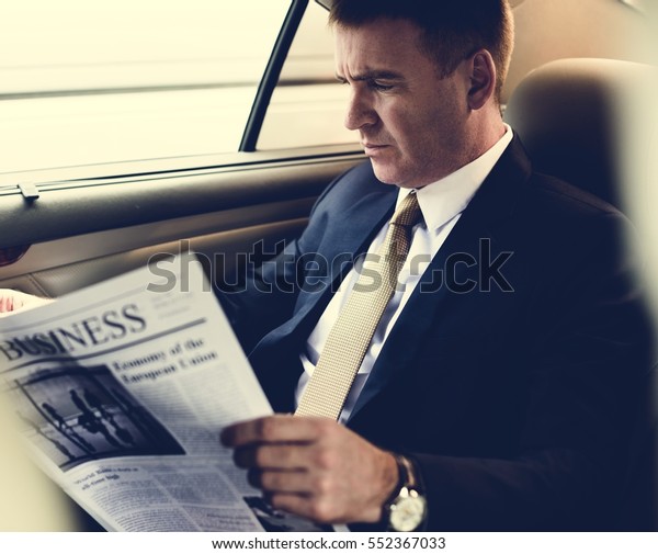 Businessman Reading\
Newspaper Car\
Inside