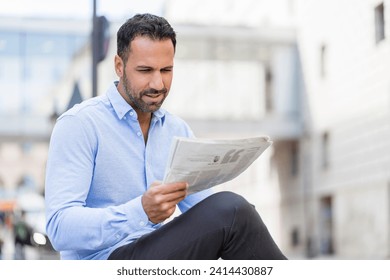 Businessman reading newspaper in the city - Powered by Shutterstock