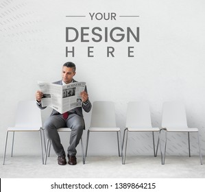 Businessman Reading A Newspaper In Front Of A Wall Mockup