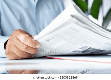 businessman reading newspaper at office - Powered by Shutterstock