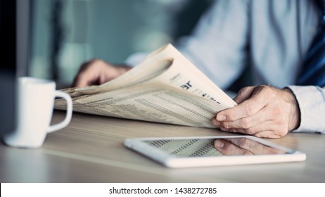 Businessman reading the newspaper on table
