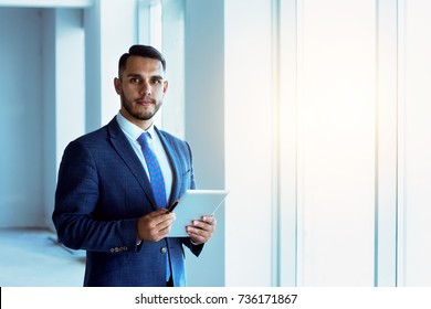 Businessman Or Real Estate Agent Stands Near Big Window In New Apartment With Tablet Computer