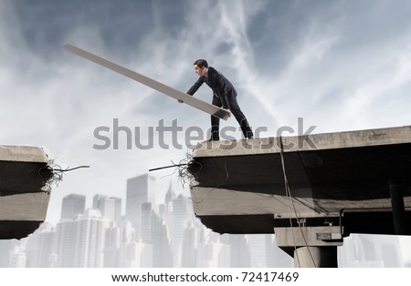 Businessman rebuilding a broken bridge