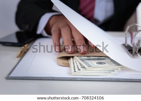 Businessman receive money in the envelope offered in file - anti bribery and corruption concepts