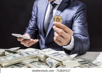 Businessman receive a lot of Money from Smartphone, Businessman Holding Bitcoin Isolated on black background, Digital Money and Bitcoine Concept.