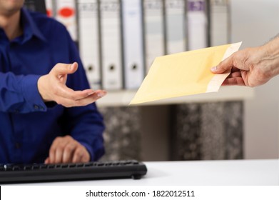 Businessman receiving a padded envelope sitting on a desk at office