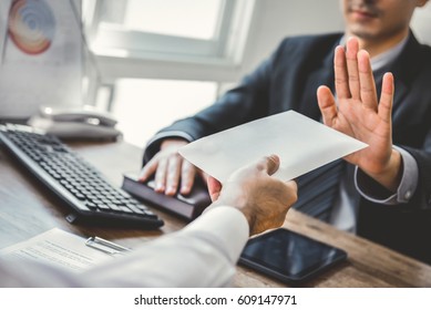 Businessman refusing money in the envelope - anti bribery and corruption concepts - Shutterstock ID 609147971