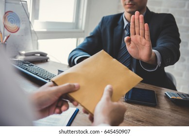 Businessman refusing money in the envelope offered by a man - anti bribery and corruption concepts - Shutterstock ID 645450907