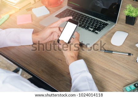 Businessman relaxing while using smartphone blank screen for graphics display montage. Over the shoulder view of