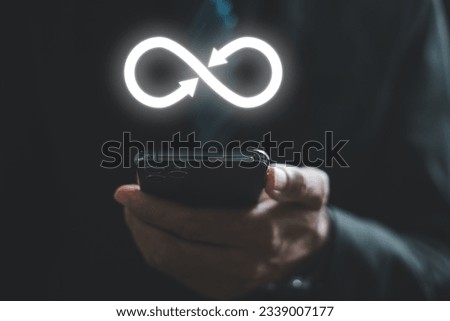 Businessman reveals smartphone with infinity symbol, representing unlimited connection in data technology. Cyber space, future unlimited. Infinite power, internet information. technology infinity data