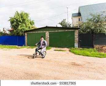 Businessman Riding Child's Bicycle. Man On A Children's Bike