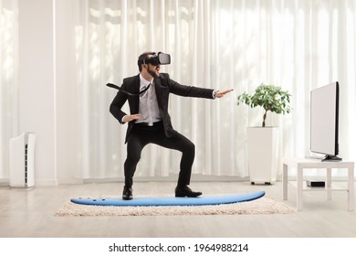 Businessman riding a surfboard with a VR headset at home - Powered by Shutterstock