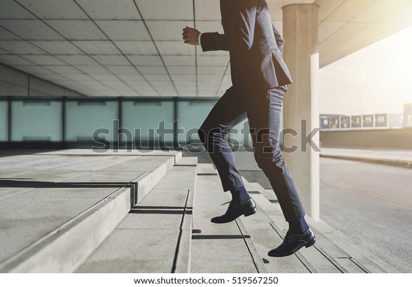 Businessman running fast upstairs. Horizontal\
outdoors shot.