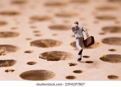 Businessman running while avoiding many potholes