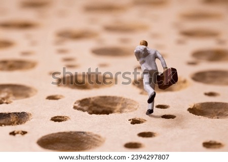 Businessman running while avoiding many potholes