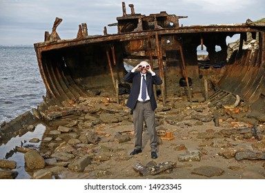 Businessman In The Rusting Hull Of Shipwreck, With Binoculars Looking Out To The Horizon, For A Brighter Business Future