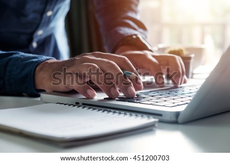 Businessman s hands typing on laptop keyboard in morning light (computer, typing, online)
