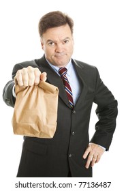 Businessman Saving Money By Bringing His Lunch To Work In A Brown Bag.  He Doesn't Look Happy.  Isolated.