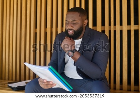 A businessman scrutinizing the documents and looking serious