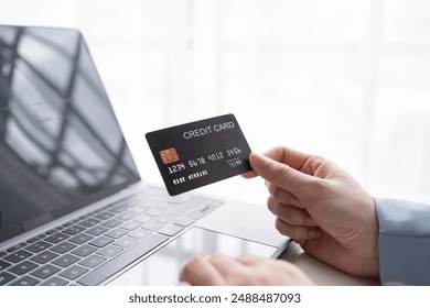 Businessman securely enters payment details online with a credit card and laptop, showcasing the convenience of e commerce in today's digital age - Powered by Shutterstock