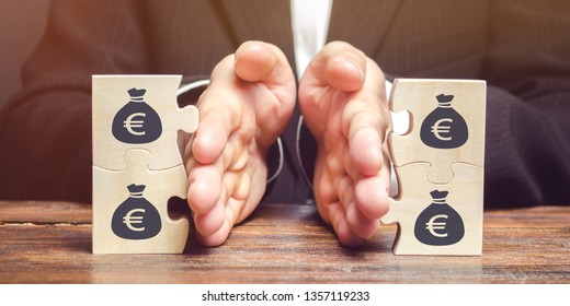 Businessman separates the wooden puzzle with a picture of money. The concept of financial management and distribution of funds. Saving and investing. Property division. Divorce and legal services - Shutterstock ID 1357119233
