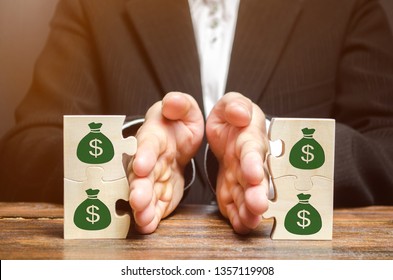 Businessman separates the wooden puzzle with a picture of money. The concept of financial management and distribution of funds. Saving and investing. Property division. Divorce and legal services
