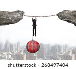 Businessman shackled by debt concrete ball hanging on iron chains connected two cliffs with urban scene background