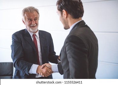 Businessman Shake Hand Together. Young Asian Businessman In Suit With Old Man Shaking Hands.