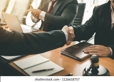Businessman shaking hands to seal a deal with his partner lawyers or attorneys discussing a contract agreement - Shutterstock ID 1126618757