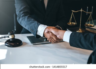 Businessman shaking hands to seal a deal with his partner lawyers or attorneys discussing a contract agreement. - Shutterstock ID 1414855517