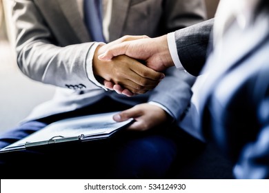 businessman shaking hands to seal a deal with his partner - Shutterstock ID 534124930