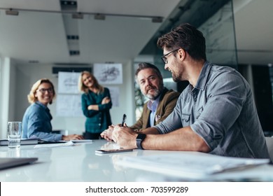 Businessman sharing ideas on project in conference room. Group of business people in meeting at office. - Shutterstock ID 703599289