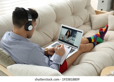 Businessman in shirt and underwear having video call on laptop at home - Shutterstock ID 1933818809