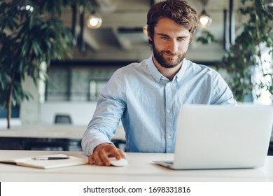 Businessman in shirt working on his laptop in an office. Open space office